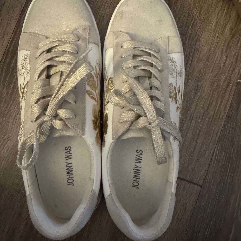 Johnny was leather sneakers with embroidery on the sides